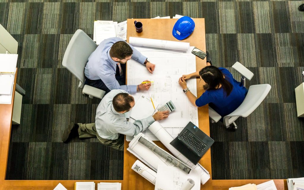 View from above of coworkers looking at blueprints